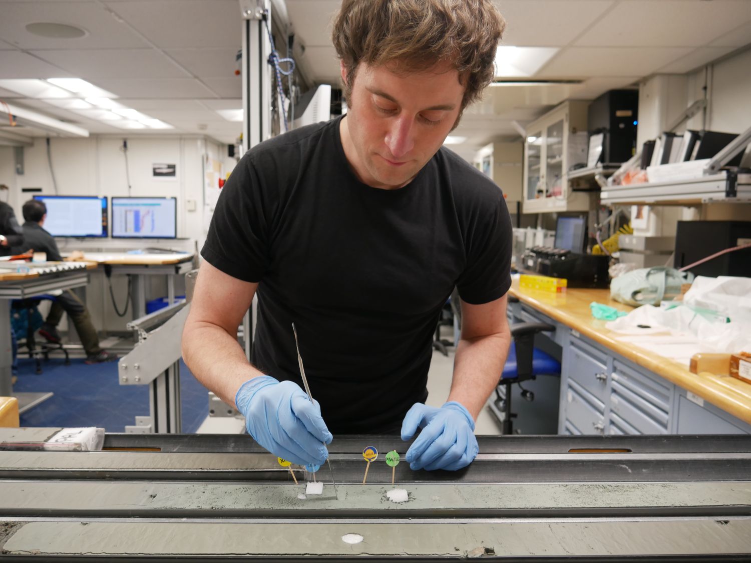 The organic geochemist Thorsten Bauersachs from Kiel University takes samples from a drill core, which the researchers have won on their current expedition into the Amundsen See. Foto: Masako Yamane